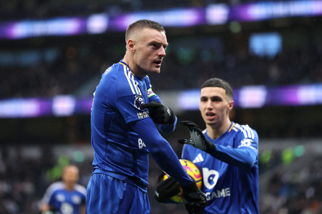 Jamie Vardy points to Premier League badge after scoring for Leicester City vs Tottenham.