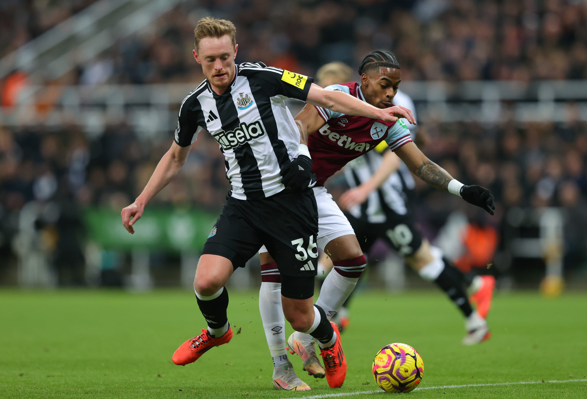 Sean Longstaff of Newcastle United holds off a challenge from Crysencio Summerville of West Ham United.