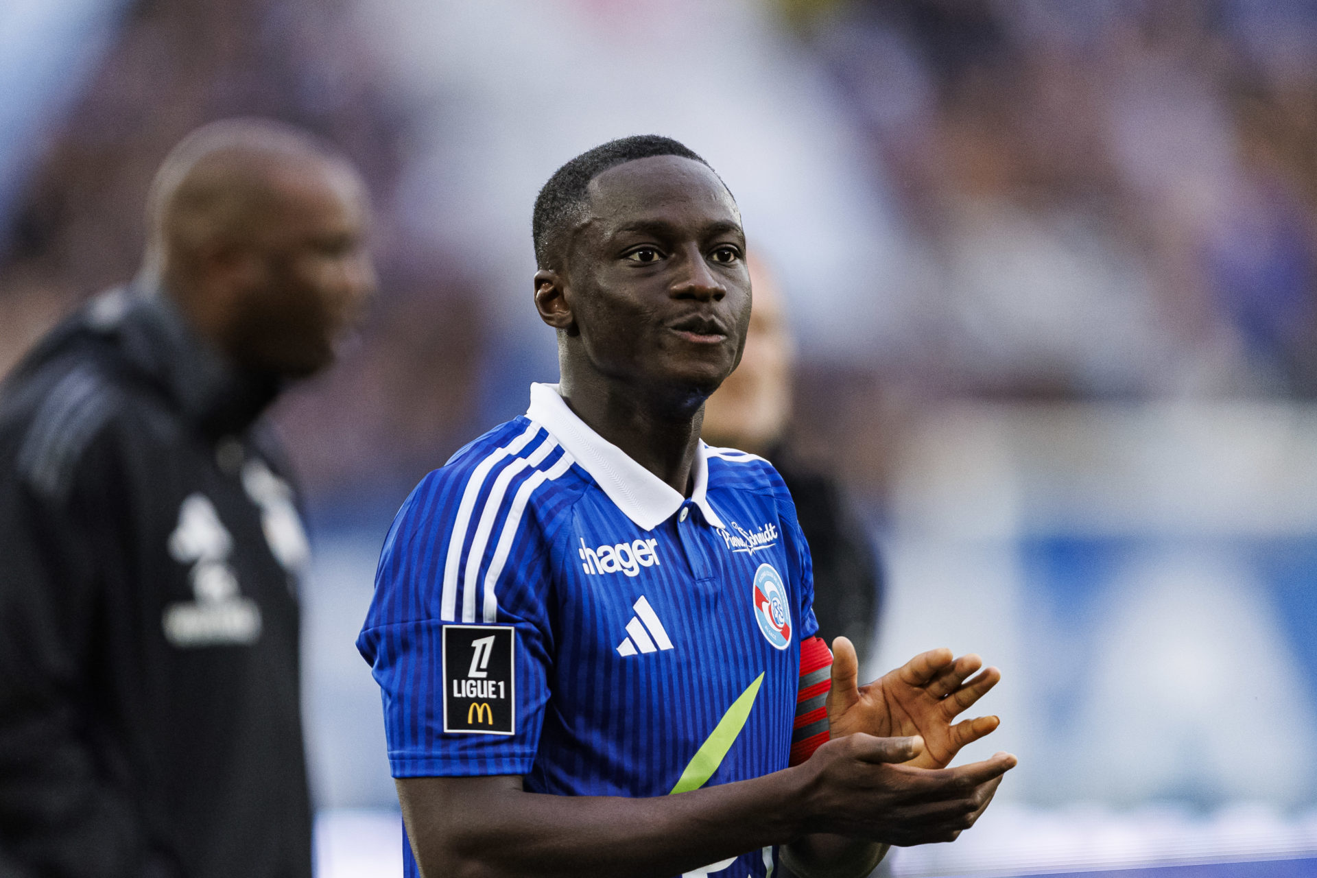 RC Strasbourg midfielder Habib Diarra claps fans.