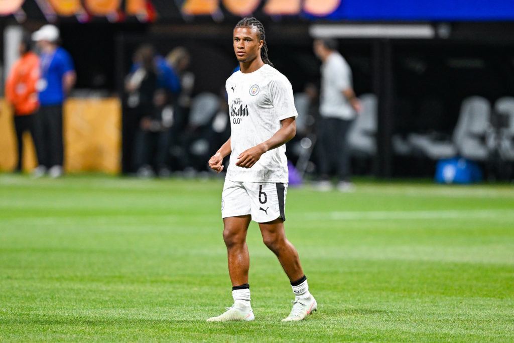 Nathan Ake warms up for Man City.
