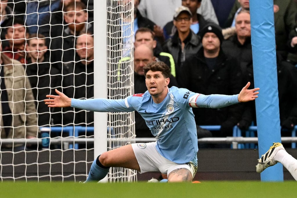 Manchester City defender John Stones spreads his arms.