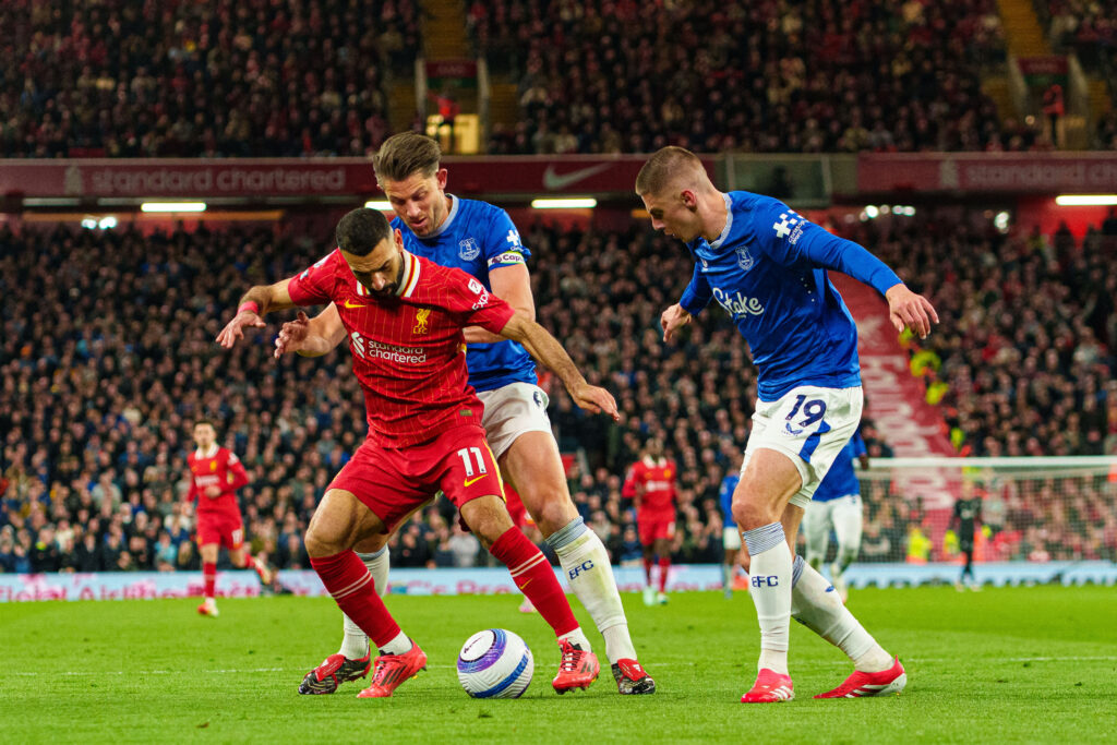 Mo Salah is challenged by James Tarkowski and Vitalii Mykolenko of Everton.