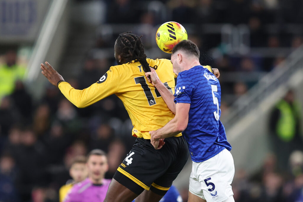Michael Keane jostles with Tolu Arokodare.