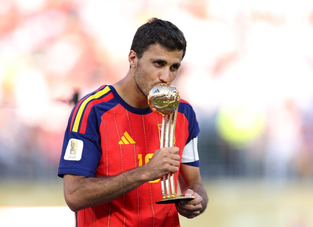 Rodri kisses the Golden Ball trophy.